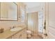 Well-lit bathroom featuring a tile countertop, vanity, and a shower-tub combo with curtain at 1137 N Lake Shore Dr, Sarasota, FL 34231