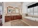 Bathroom with granite counters, tub, and a decorative rug with natural light streaming through the shutters at 1137 N Lake Shore Dr, Sarasota, FL 34231
