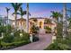 Luxury home featuring lush landscaping, tile roof, columned entry, and a brick driveway at 1137 N Lake Shore Dr, Sarasota, FL 34231