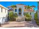 Luxury home featuring a tile roof, columned entry, brick driveway, lush landscaping, and attached garages at 1137 N Lake Shore Dr, Sarasota, FL 34231
