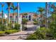 Luxury home with tile roof, columned entry, wrought iron gate, circular brick driveway, and lush landscaping at 1137 N Lake Shore Dr, Sarasota, FL 34231
