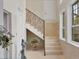 Bright foyer with stone floors, staircase with iron railing, and decorative accents at 1137 N Lake Shore Dr, Sarasota, FL 34231