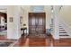 Grand foyer showcasing hardwood floors, a striking double door, staircase, and classic architectural details at 1137 N Lake Shore Dr, Sarasota, FL 34231