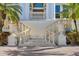 Elegant entryway with columns, stone steps, ornamental urns, and lush tropical landscaping at 1137 N Lake Shore Dr, Sarasota, FL 34231
