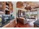 Wet bar and open living area with custom cabinets, wood floors and a ceiling fan at 1137 N Lake Shore Dr, Sarasota, FL 34231