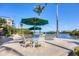 Waterfront patio with umbrella-shaded seating offering serene views of the water and lush surroundings, perfect for relaxation at 1137 N Lake Shore Dr, Sarasota, FL 34231