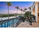 Spectacular waterfront view from a balcony overlooking a pool, boat dock, and palm trees at sunset at 1137 N Lake Shore Dr, Sarasota, FL 34231