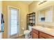 Bathroom features a single vanity sink, toilet, and a window for natural light at 11411 Flora Springs Dr, Riverview, FL 33579