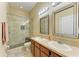 Bathroom featuring dual sinks, wood cabinets, tile flooring, and a glass enclosed shower at 11411 Flora Springs Dr, Riverview, FL 33579