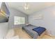 Bedroom with light-gray walls, plush carpet, a large window and a ceiling fan with lights at 11411 Flora Springs Dr, Riverview, FL 33579