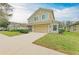 Two-story tan home featuring a well-manicured lawn, and a two-car garage at 11411 Flora Springs Dr, Riverview, FL 33579