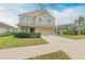 Two-story tan home featuring a well-manicured lawn, and a two-car garage at 11411 Flora Springs Dr, Riverview, FL 33579