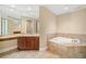 Bright bathroom features tile flooring, a soaking tub, and vanity with granite countertop at 130 Riviera Dunes Way # 1201, Palmetto, FL 34221