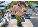 An aerial view of a building with a unique terra cotta colored roof surrounded by palm trees at 130 Riviera Dunes Way # 1201, Palmetto, FL 34221