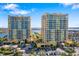 Exterior view of two condo buildings with palm trees and a parking area in the surrounding landscape at 130 Riviera Dunes Way # 1201, Palmetto, FL 34221