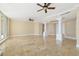 Bright living room featuring travertine flooring, columns, ceiling fans, and sliding glass doors at 130 Riviera Dunes Way # 1201, Palmetto, FL 34221