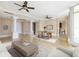 Spacious living room features travertine flooring, columns, ceiling fans, and views of the water at 130 Riviera Dunes Way # 1201, Palmetto, FL 34221