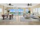 Living room with travertine floors, dining table, sofa, ceiling fans and sliding glass doors to the outside at 130 Riviera Dunes Way # 1201, Palmetto, FL 34221