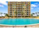 Outdoor swimming pool with lounge chairs, and palm trees at 130 Riviera Dunes Way # 1201, Palmetto, FL 34221