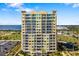Condo high-rise featuring multiple balconies, waterfront views, and tropical landscaping at 130 Riviera Dunes Way # 902, Palmetto, FL 34221