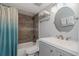 Bathroom featuring a tub, shower, and a vanity with a round mirror and towel rack at 1300 Gulf Blvd # 202, Indian Rocks Beach, FL 33785