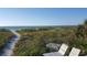 Beautiful beach view with lounge chairs and clear blue sky overlooking grassy dunes at 1300 Gulf Blvd # 202, Indian Rocks Beach, FL 33785