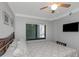 Cozy bedroom with a ceiling fan, a window with blinds, and a wall-mounted TV at 1300 Gulf Blvd # 202, Indian Rocks Beach, FL 33785