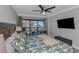 Bright bedroom with a balcony view, ceiling fan and patterned bedding with matching pillows at 1300 Gulf Blvd # 202, Indian Rocks Beach, FL 33785