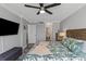 Comfortable bedroom featuring a large TV, ceiling fan and patterned bedding with matching pillows at 1300 Gulf Blvd # 202, Indian Rocks Beach, FL 33785
