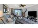 Comfortable living room features a blue leather couch and a balcony with a water view at 1300 Gulf Blvd # 202, Indian Rocks Beach, FL 33785