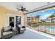 A covered balcony with lounge chairs offers views of the pool, greenery, and building exterior at 14021 Bellagio Way # 309, Osprey, FL 34229