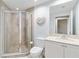 Bathroom featuring a tiled walk-in shower and a toilet with a sink and cabinet at 14021 Bellagio Way # 309, Osprey, FL 34229