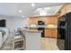 Open kitchen with wooden cabinets, a granite breakfast bar, and modern appliances at 14021 Bellagio Way # 309, Osprey, FL 34229