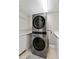 Laundry room complete with modern washer and dryer, folding counter, and storage shelf at 14021 Bellagio Way # 309, Osprey, FL 34229