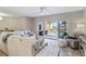 Living room with neutral furniture, an area rug and sliding door access to the balcony at 14021 Bellagio Way # 309, Osprey, FL 34229