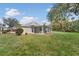 Backyard view of home featuring large grass yard and enclosed sunroom at 2 Antigua Cir # 4, Englewood, FL 34223