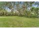 Expansive backyard featuring lush grass and mature shade trees at 2 Antigua Cir # 4, Englewood, FL 34223