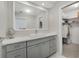 Bright bathroom with a white quartz countertop, grey cabinets, and a view into the walk-in closet at 2 Antigua Cir # 4, Englewood, FL 34223
