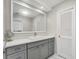 Bright bathroom featuring a white quartz countertop, grey cabinets, and a large mirror at 2 Antigua Cir # 4, Englewood, FL 34223