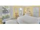 Bright bedroom with white shutters, sunny yellow walls, and cheerful decor creating a peaceful atmosphere at 2 Antigua Cir # 4, Englewood, FL 34223
