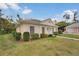 Low angle view of single-story home featuring manicured front lawn and mature landscaping at 2 Antigua Cir # 4, Englewood, FL 34223