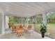 Bright sunroom with tile floor, walls of windows, and casual seating with orange striped cushions at 2 Antigua Cir # 4, Englewood, FL 34223