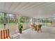 Enclosed sunroom featuring white tile floor, walls of windows, and backyard views at 2 Antigua Cir # 4, Englewood, FL 34223