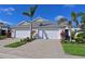 Charming villa with a two-car garage, brick paved driveway and tropical landscaping at 209 Okeeffe Cir, Bradenton, FL 34212