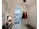 Bright hallway leading to the laundry room with modern decor, lighting and adjacent coat rack at 209 Okeeffe Cir, Bradenton, FL 34212