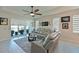Bright living room with tile flooring, modern ceiling fan, and sliding glass doors to the outdoor patio at 209 Okeeffe Cir, Bradenton, FL 34212