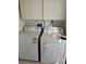 Functional laundry area with a washer, dryer, and overhead storage cabinets at 216 Amherst Ave # 97, Sarasota, FL 34232