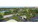 Aerial view of the condo community featuring lush landscaping, a scenic pond, covered parking, and distant water views at 2320 Terra Ceia Bay Blvd # 808, Palmetto, FL 34221