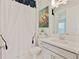 Bright bathroom featuring a single sink vanity with white cabinets and stylish shower curtain at 3008 Tolmino Ct, Lakewood Ranch, FL 34211