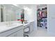 Bright bathroom featuring double sinks, a vanity and an adjacent walk-in closet at 3008 Tolmino Ct, Lakewood Ranch, FL 34211